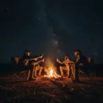 Hunters gathered around a Texas campfire at night under a starry sky